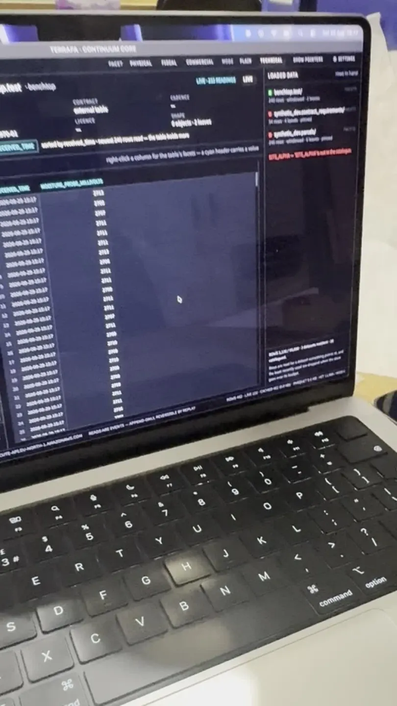 Photograph of a laptop running Continuum Core on its Data Sources tab, with a live feed listed on the right and a table of timestamped readings filling on the left.